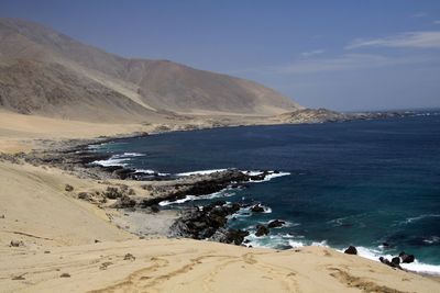 Scenic view of sea and mountains against sky