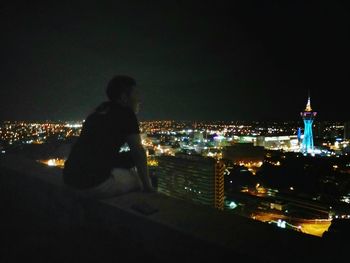 Man with illuminated cityscape at night