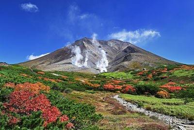 Scenic view of mountain against blue sky