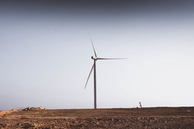 Windmill on field against clear sky