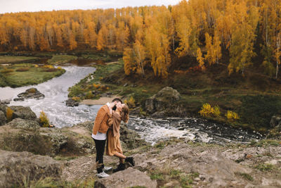 Happy people in love are travel hike in nature in the autumn forest. romantic trip to countryside