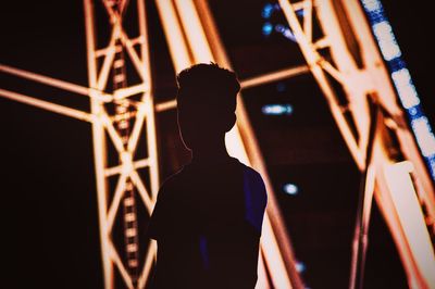 Rear view of silhouette man standing at night