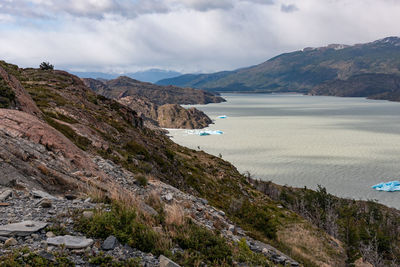 Scenic view of sea and mountains against sky