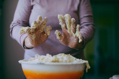 Cropped hands of woman kneading dough