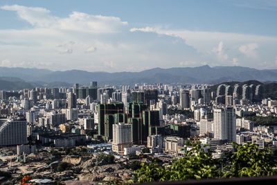 Aerial view of buildings in city against sky