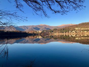 Scenic view of lake and mountains against blue sky