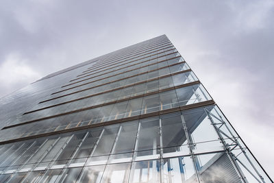 Low angle view of glass building against sky