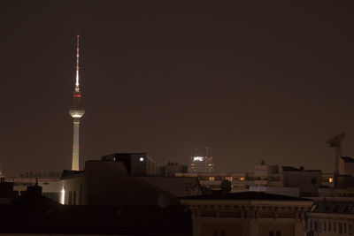 Illuminated buildings in city against sky at night