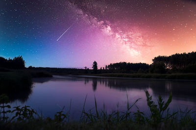 Scenic view of lake against sky at night