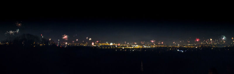 Illuminated cityscape against sky at night