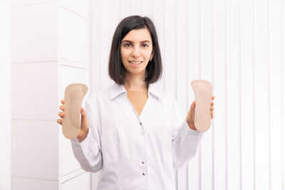 Portrait of doctor holding insoles