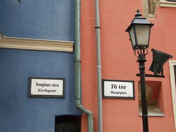 Low angle view of street light against building wall