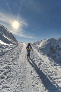 A child with mountaineering skis on a climb on italian alps