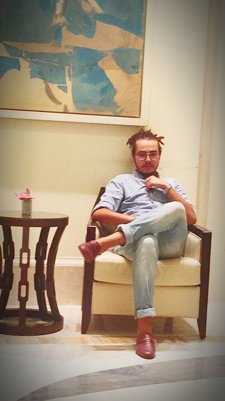 PORTRAIT OF MATURE MAN SITTING IN ROOM