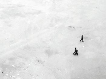 High angle view of people walking on snow