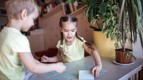 Cute kids playing with cards on table