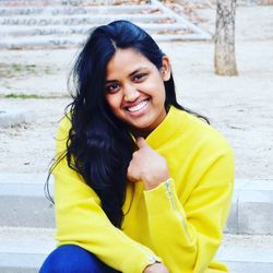 Portrait of smiling young woman sitting outdoors