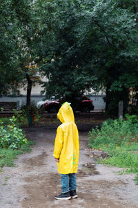 A lonely boy in a yellow raincoat got lost in the park