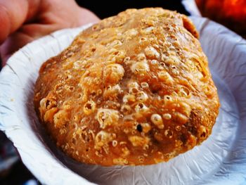 Close-up of hand holding fried food in bowl