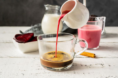 Espresso with beetroot latte pouring to cup and basic ingredients.