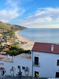 High angle view of townscape by sea against sky