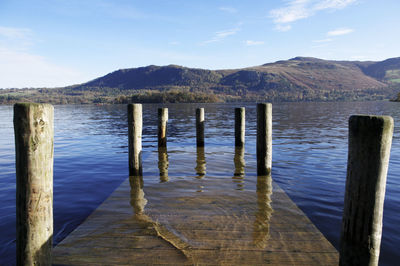 Pier at lake against sky