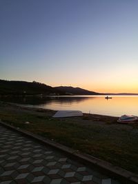 Scenic view of lake against clear sky during sunset