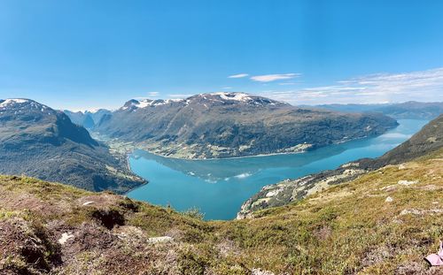 Panoramic view of lake and mountains against blue sky