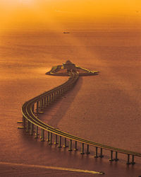 High angle view of road by sea against sky during sunset