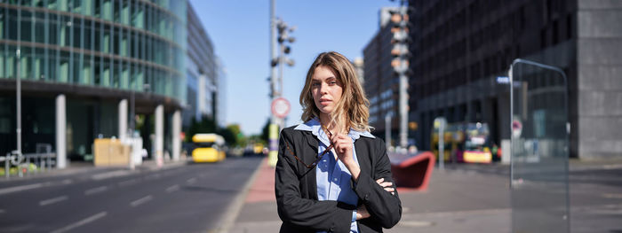 Low section of woman standing in city