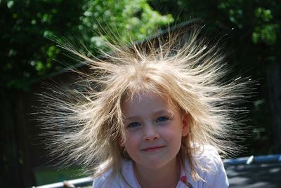 Close-up portrait of girl with hair toss standing at park