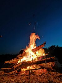 Bonfire on wooden structure against sky at night