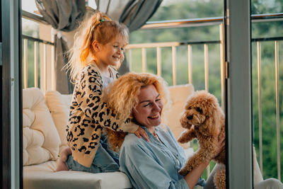 Side view of young woman with dog at home