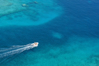 High angle view of turquoise sea with speed boat