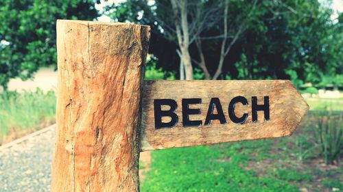 Close-up of beach text of wooden post