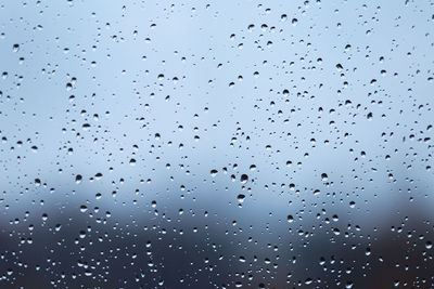 Full frame shot of wet glass window during rainy season