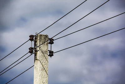 Low angle view of electricity pylon against sky