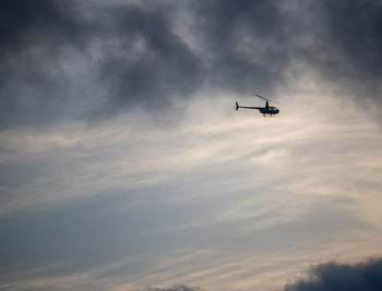 Low angle view of silhouette airplane against sky during sunset