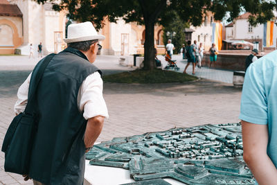 Rear view of man standing on street in city