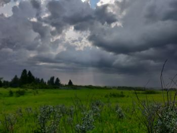 Scenic view of field against cloudy sky