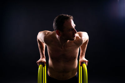 Side view of young man exercising in gym