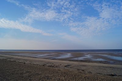 Scenic view of beach against blue sky