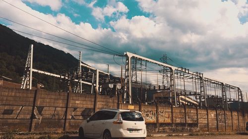 Cars on road by buildings against sky