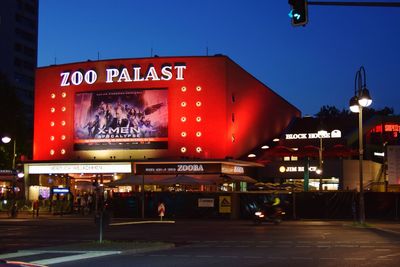 Illuminated sign against clear sky at night