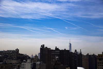 Buildings in city against blue sky