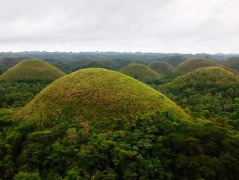 Scenic view of green landscape against sky