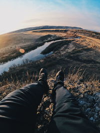 Low section of man on mountain against sky