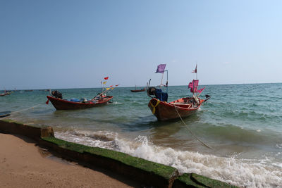 Boat moored on sea against clear sky