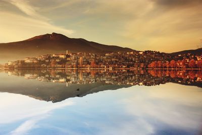 Scenic view of river and buildings against sky during sunset