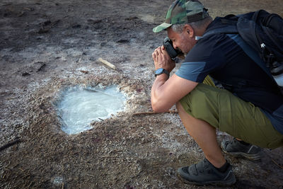 Hiker visits the caldera, a small circular crater with a marsh of sulphurous waters from the volcano